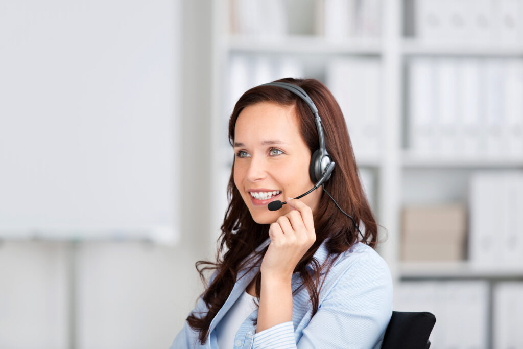 smiling,friendly,woman,wearing,a,headset,sitting,in,an,office,