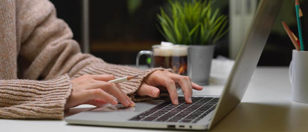 Hands typing on a laptop